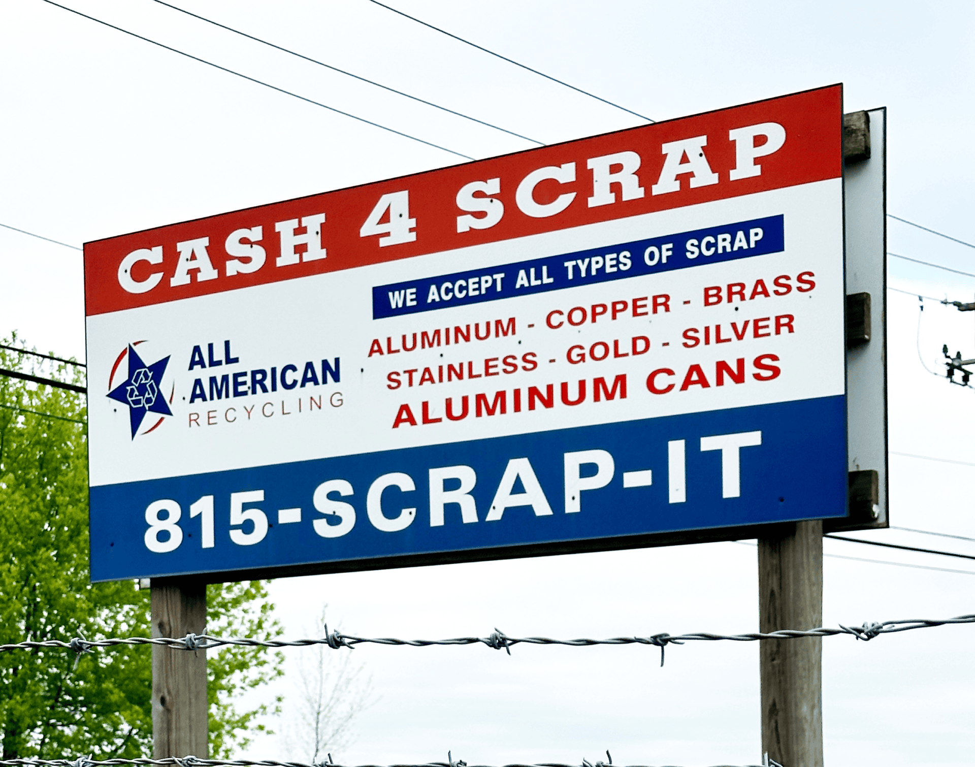 A sign reads Cash 4 Scrap and lists metals accepted for recycling, including aluminum, copper, brass, and aluminum cans. Contact number: 815-SCRAP-IT. The All American Recycling logo is on the left.